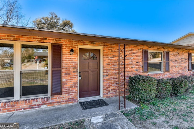 doorway to property with brick siding