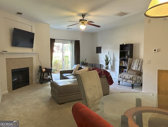 living area featuring carpet floors, visible vents, a fireplace, and a ceiling fan