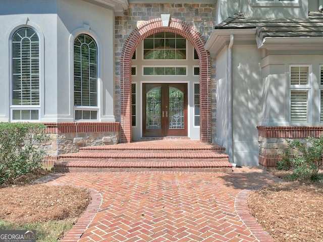 property entrance with stucco siding and french doors