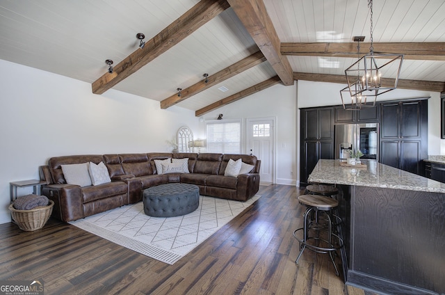 living room featuring lofted ceiling with beams, a chandelier, baseboards, and wood finished floors