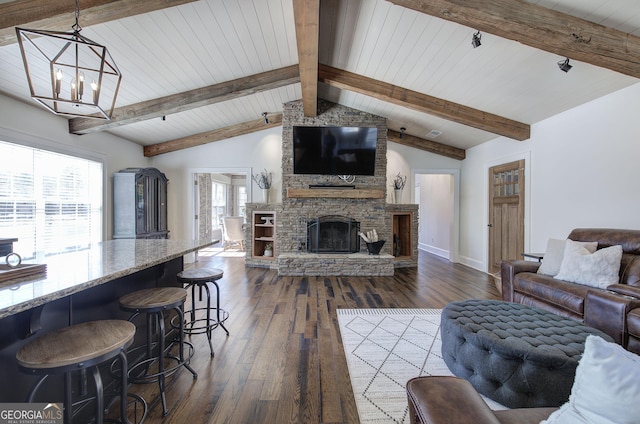 living room featuring dark wood-style floors, baseboards, vaulted ceiling with beams, a fireplace, and a chandelier