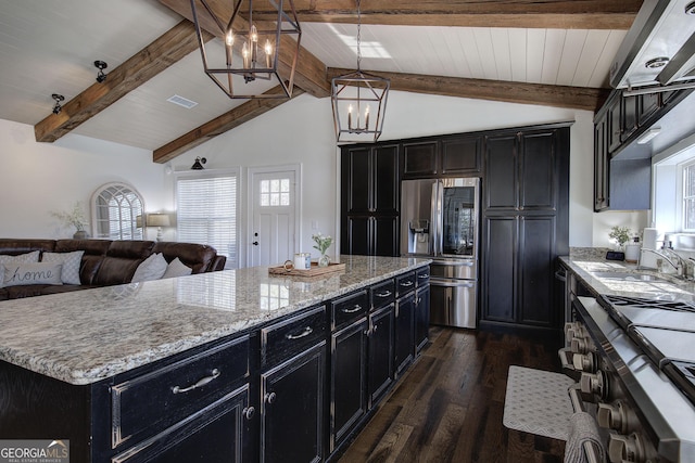 kitchen with appliances with stainless steel finishes, dark cabinetry, and a sink