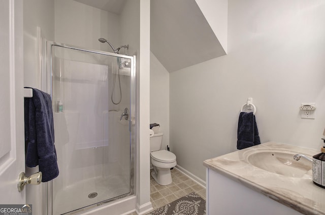 bathroom with a stall shower, toilet, vanity, and baseboards