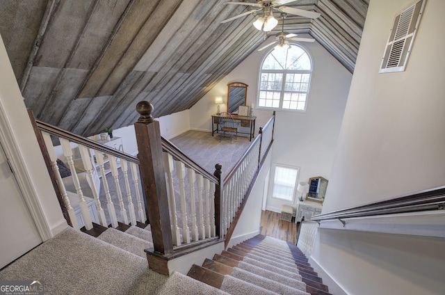 stairway featuring visible vents, baseboards, lofted ceiling, and a ceiling fan