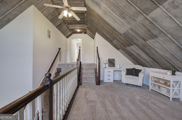 interior space featuring vaulted ceiling, carpet flooring, visible vents, and ceiling fan