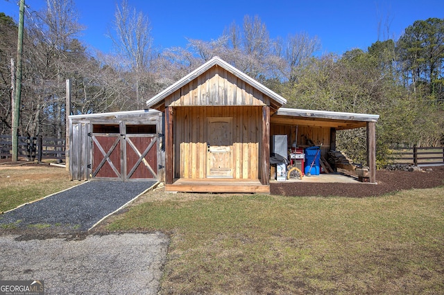 view of shed featuring an attached carport and fence