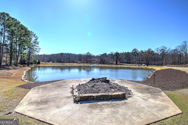 view of pool with a water view and a wooded view