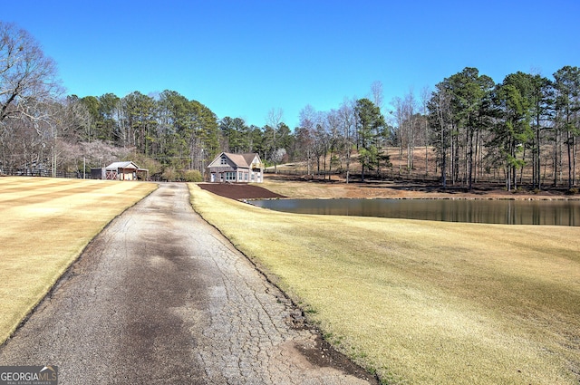 view of road featuring driveway and a water view