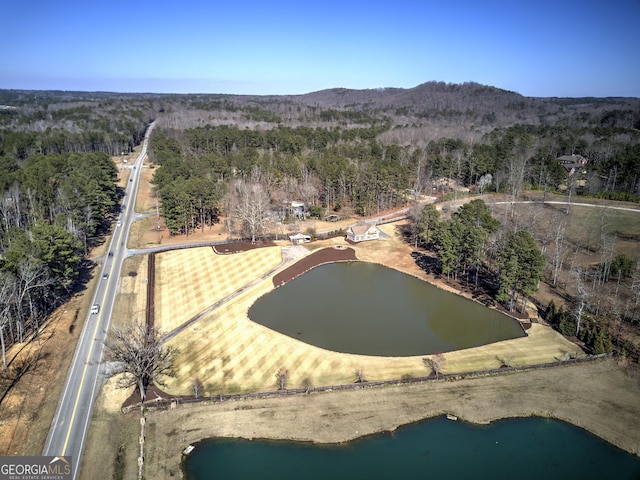 aerial view with a water view and a wooded view