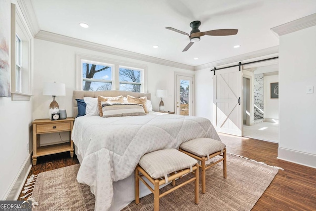 bedroom with recessed lighting, a barn door, ornamental molding, wood finished floors, and baseboards