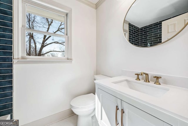 bathroom featuring toilet, baseboards, and vanity