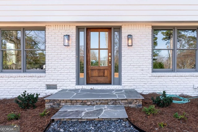 entrance to property with brick siding and crawl space