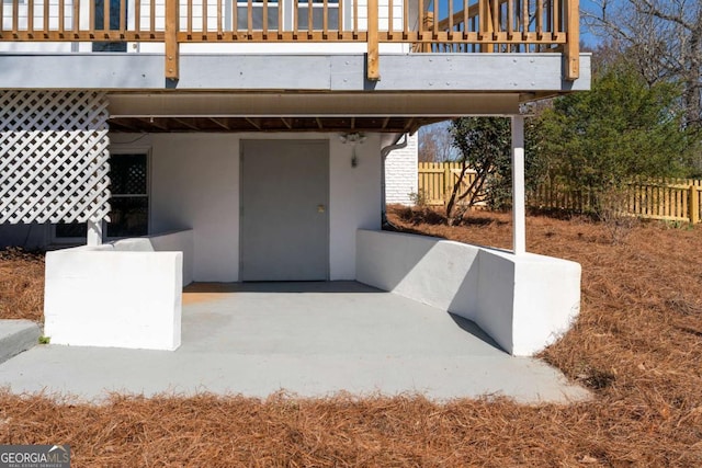 view of patio with fence and a balcony