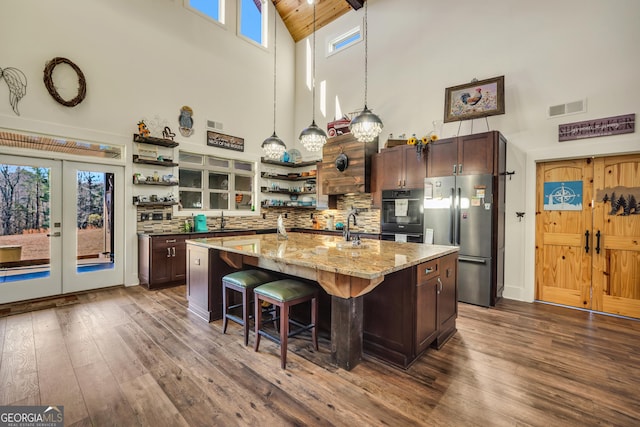 kitchen featuring freestanding refrigerator, visible vents, decorative backsplash, and open shelves