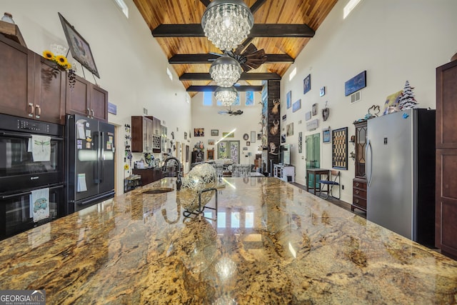 kitchen with a sink, wood ceiling, black appliances, beamed ceiling, and an inviting chandelier