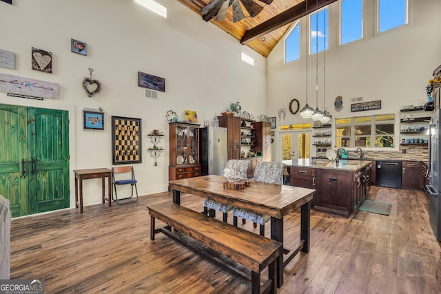 dining area featuring wood ceiling, a towering ceiling, beam ceiling, and hardwood / wood-style flooring