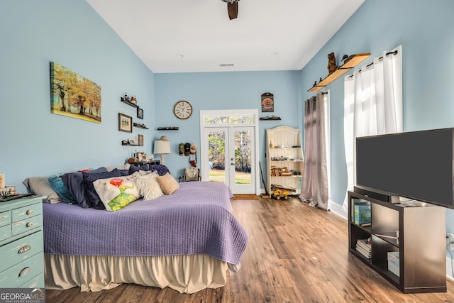 bedroom with access to exterior, wood finished floors, and french doors