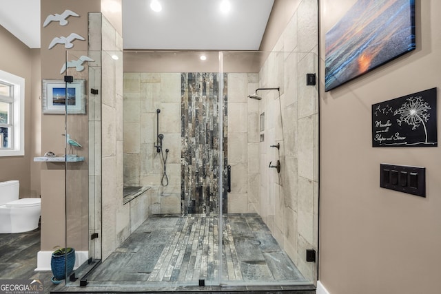 bathroom featuring toilet and a shower stall