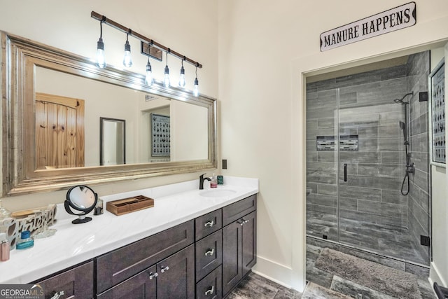 bathroom featuring a stall shower, vanity, and baseboards