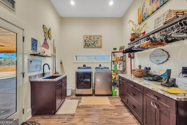 laundry room featuring washer and clothes dryer, light wood finished floors, visible vents, cabinet space, and a sink