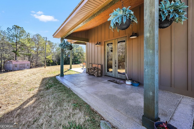 exterior space with board and batten siding, french doors, a patio area, and a yard