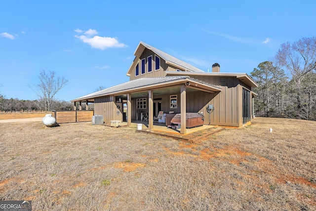 view of front of house featuring a hot tub, board and batten siding, a standing seam roof, metal roof, and cooling unit