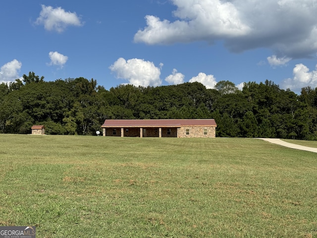 view of front of property with a view of trees and a front lawn