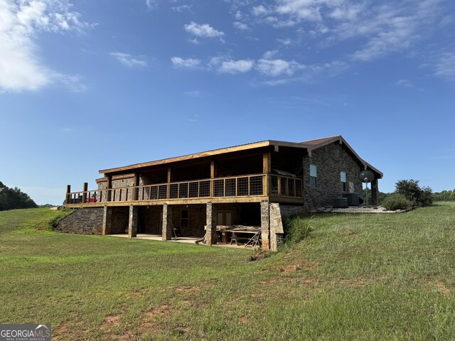 view of front of house featuring driveway, stone siding, a garage, and a front lawn