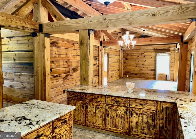 kitchen featuring a peninsula, a sink, freestanding refrigerator, brown cabinets, and beamed ceiling