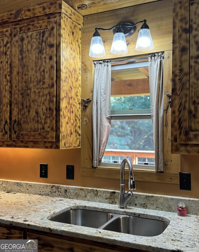 kitchen featuring brown cabinets, light stone countertops, and stainless steel appliances