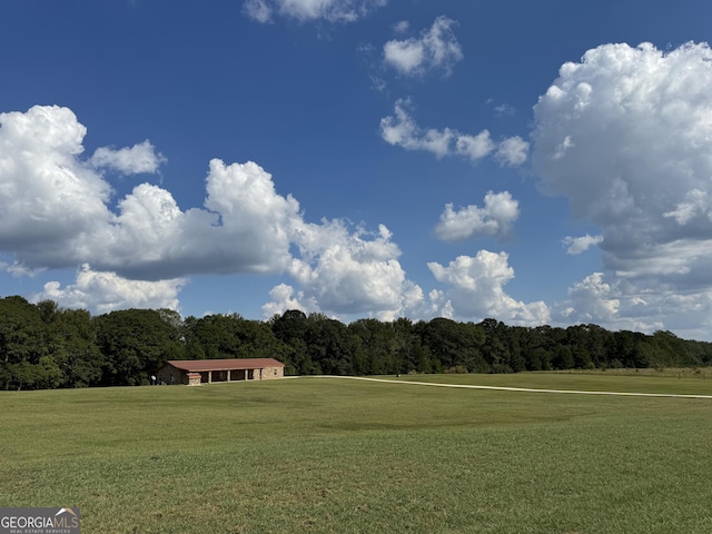 surrounding community with a view of trees and a lawn