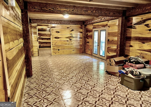 interior space featuring french doors, wood walls, and tile patterned floors