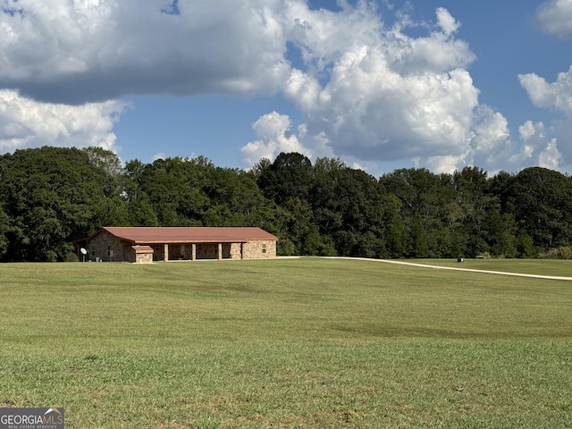 view of community featuring a wooded view and a yard