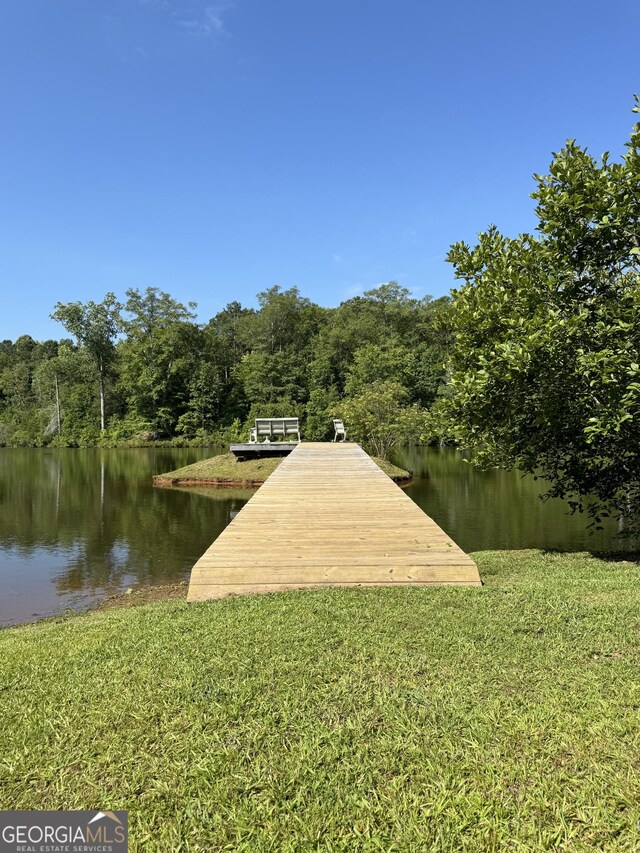 view of dock featuring a water view and a forest view