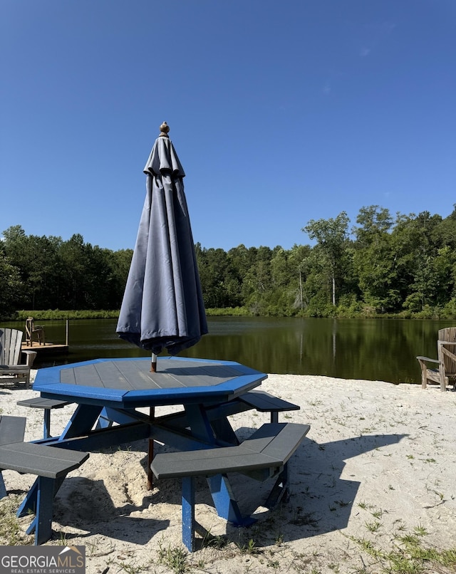 view of property's community with a water view and a view of trees