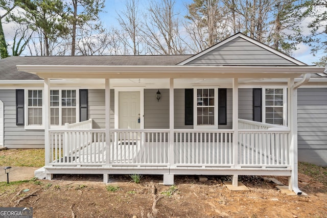 view of front of house featuring covered porch and a shingled roof