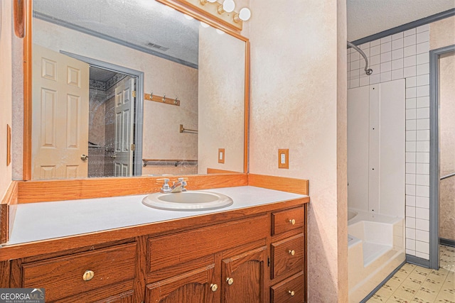 full bathroom with visible vents, a textured wall, tile patterned floors, a textured ceiling, and vanity