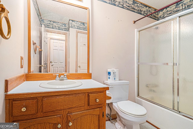 bathroom with combined bath / shower with glass door, a textured ceiling, toilet, and vanity