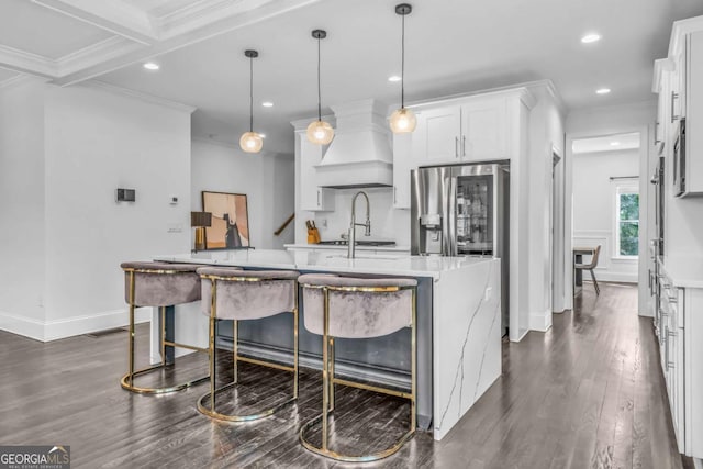 2850 Stonehall Ct SE, Smyrna, GA 30339 - kitchen with custom range hood, dark wood finished floors, crown molding, and stainless steel fridge with ice dispenser