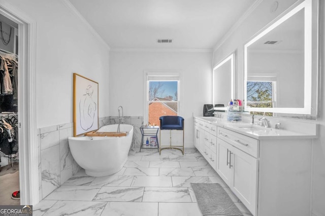 2850 Stonehall Ct SE, Smyrna, GA 30339 - full bathroom with visible vents, a freestanding bath, marble finish floor, ornamental molding, and double vanity