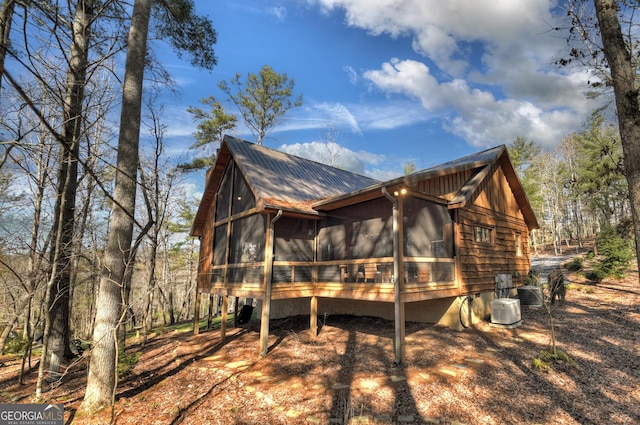 view of property exterior with a sunroom and central AC