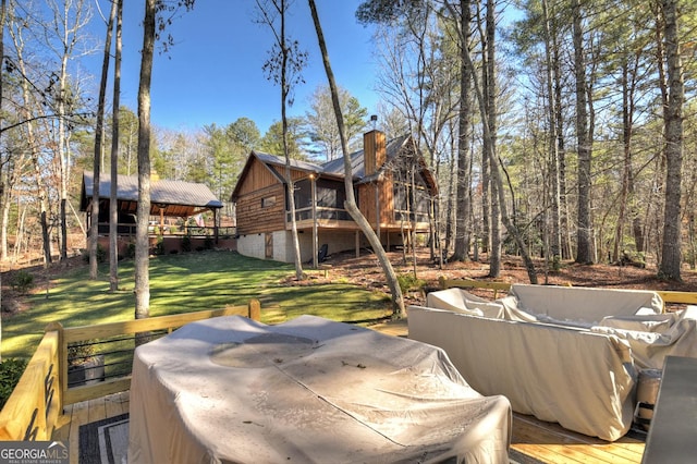 exterior space with a chimney, a deck, and a yard