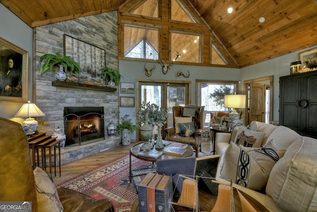 living room with vaulted ceiling, a fireplace, wood finished floors, and wooden ceiling