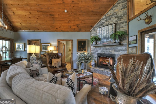 living area featuring high vaulted ceiling, a fireplace, and wooden ceiling