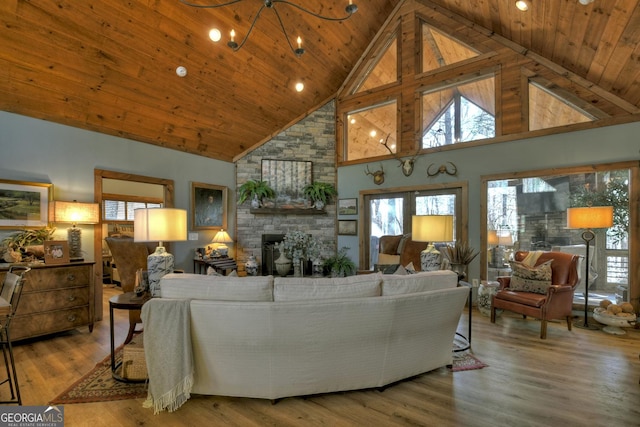 living room with a stone fireplace, wooden ceiling, wood finished floors, and a healthy amount of sunlight