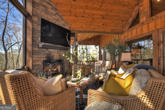 sunroom / solarium featuring lofted ceiling, wooden ceiling, and an outdoor stone fireplace