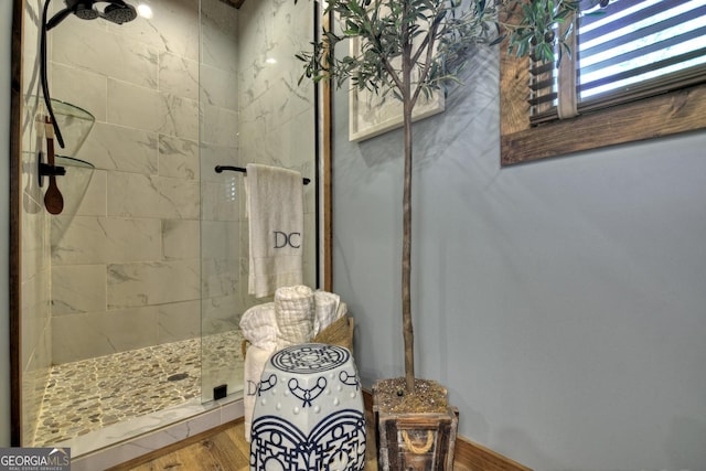 bathroom featuring wood finished floors and a tile shower