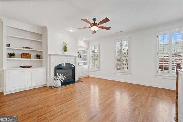 unfurnished living room featuring a fireplace with flush hearth, baseboards, crown molding, and light wood finished floors