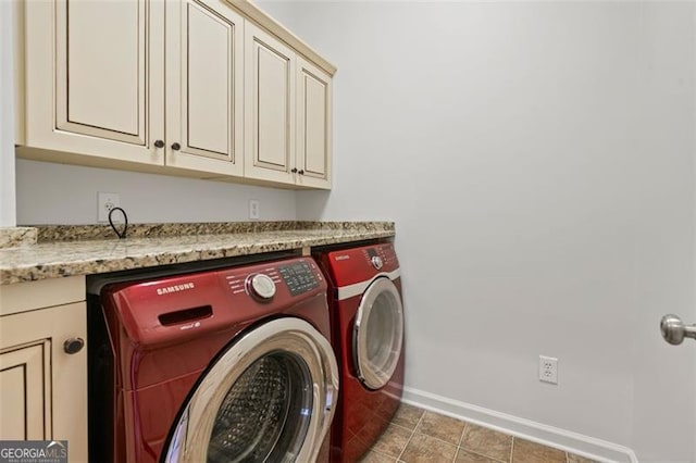 laundry room featuring washing machine and dryer, cabinet space, and baseboards