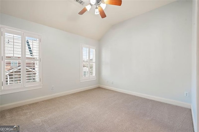 spare room featuring ceiling fan, carpet, baseboards, and vaulted ceiling